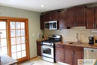 65 Wilk Road Edison, NJ 08837 - Photo 5 of 17 a kitchen with granite countertop wooden cabinets stainless steel appliances and a window