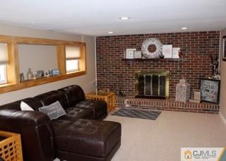 65 Wilk Road Edison, NJ 08837 - Photo 9 of 17 a living room with furniture a fireplace and a flat screen tv