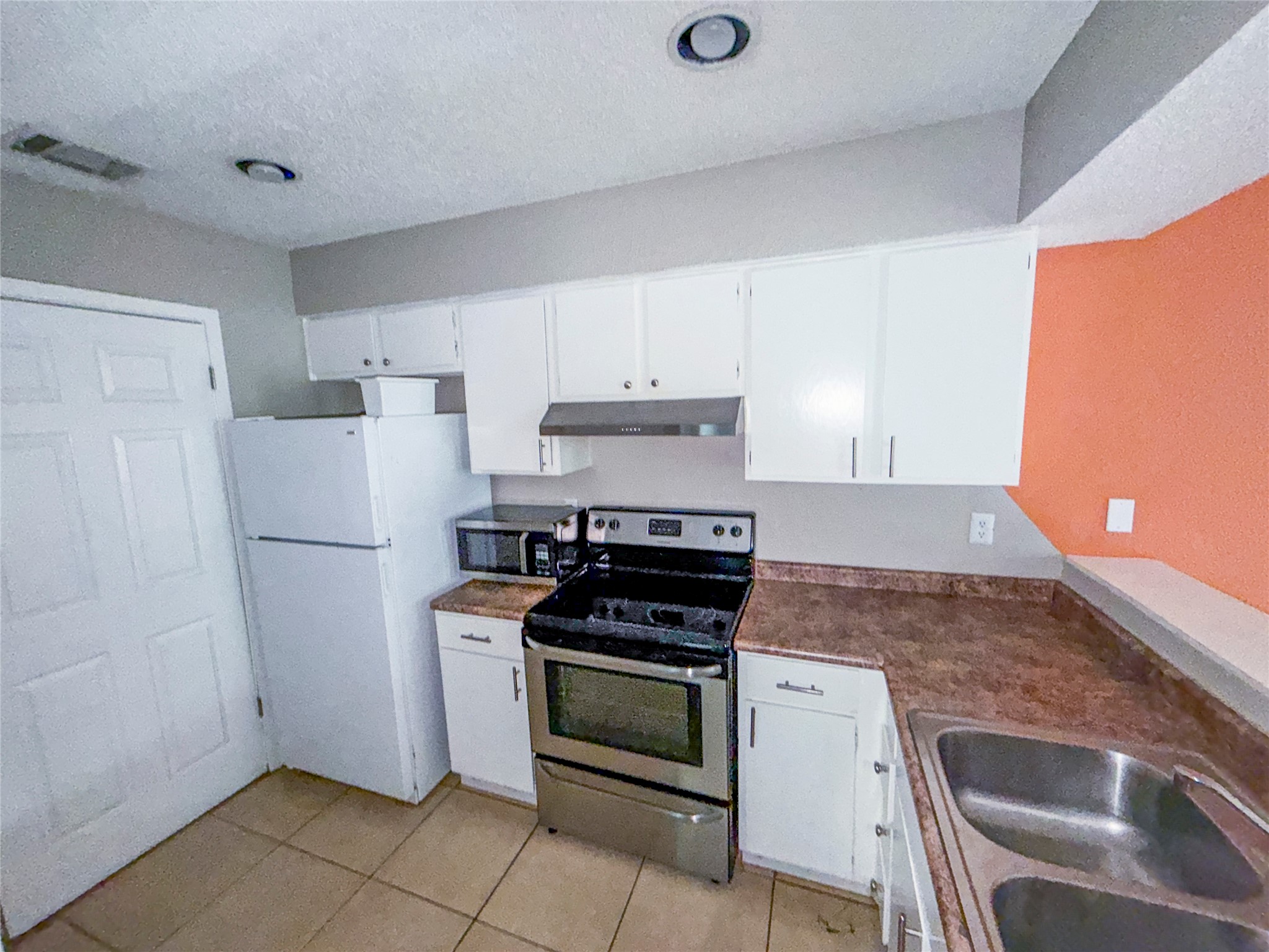 5313 Indio Drive, Unit D Austin, TX 78745 - Photo 7 of 17 a kitchen with white cabinets and white appliances