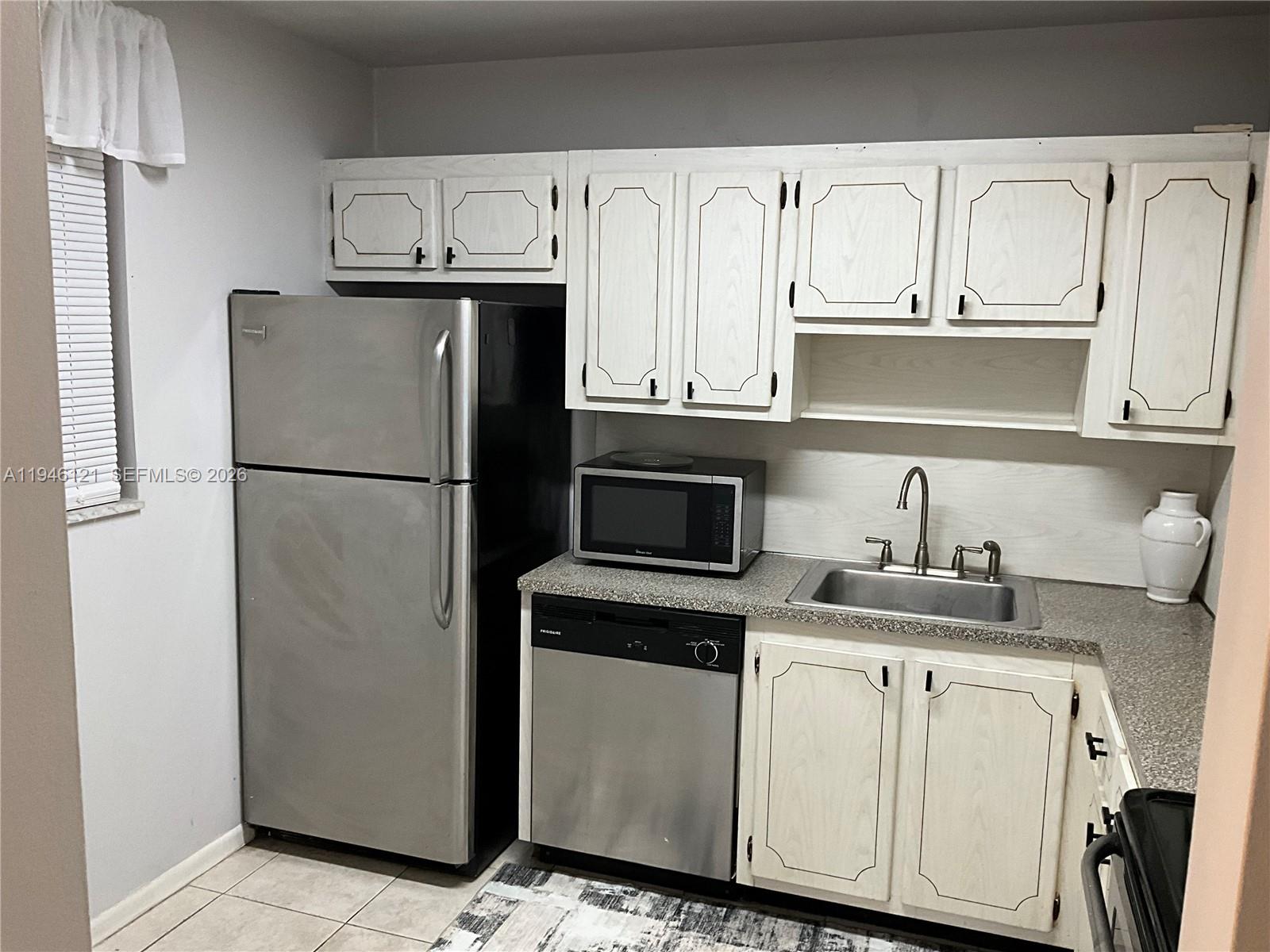 101 Berkley Road, Unit 205 Hollywood, FL 33024 - Photo 2 of 13 a kitchen with stainless steel appliances granite countertop a refrigerator sink and cabinets