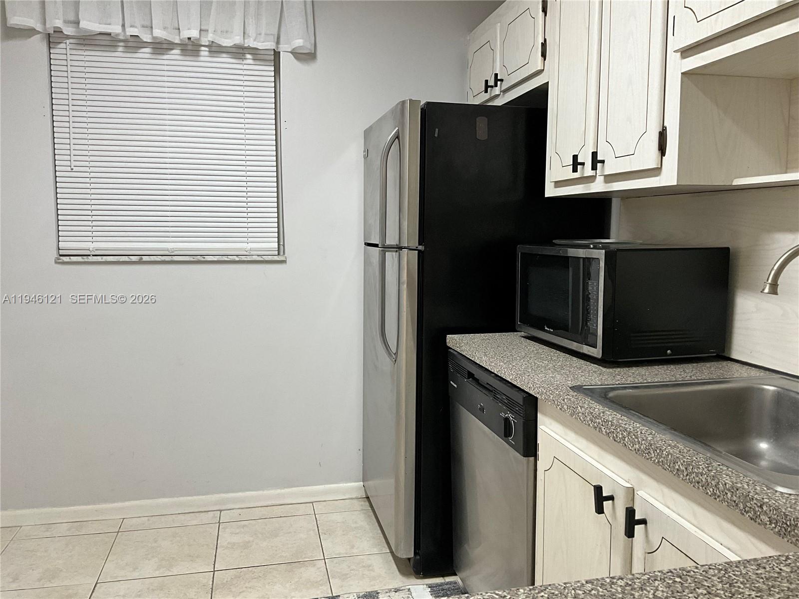 101 Berkley Road, Unit 205 Hollywood, FL 33024 - Photo 4 of 13 a kitchen with granite countertop a refrigerator and a sink