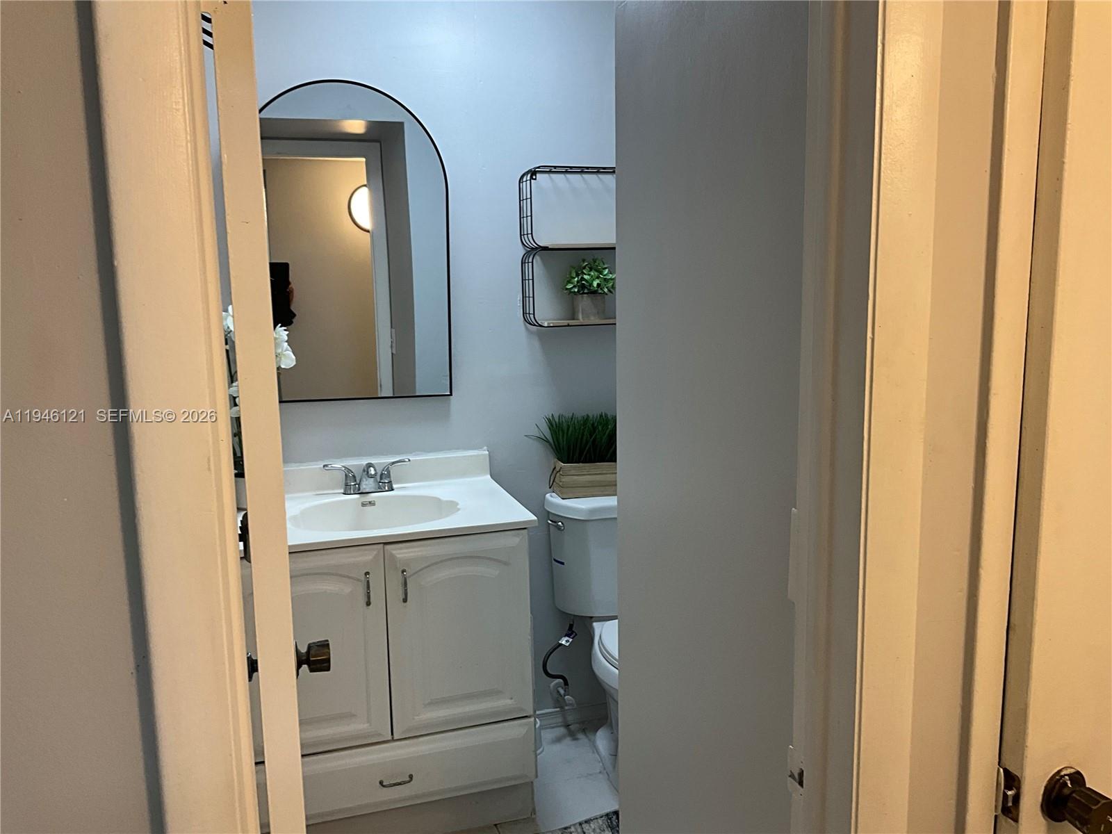 101 Berkley Road, Unit 205 Hollywood, FL 33024 - Photo 9 of 13 a bathroom with a toilet sink and mirror