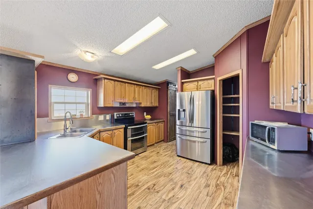 a kitchen with stainless steel appliances granite countertop a refrigerator stove and sink