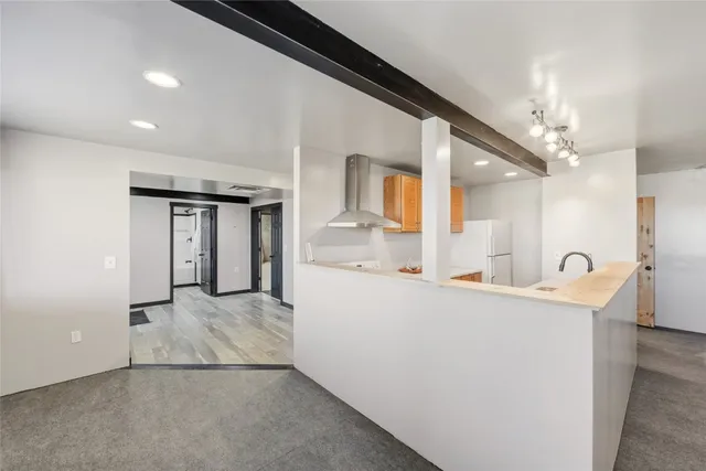 an empty room with a chandelier fan and windows