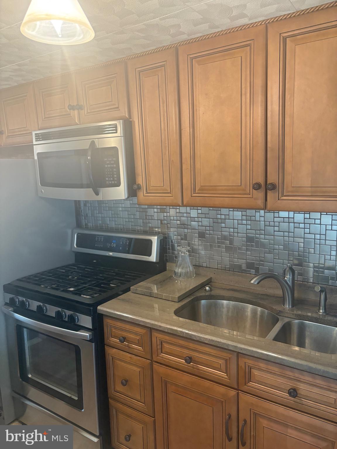 11829 Academy Road, Unit 29B Philadelphia, PA 19154 - Photo 7 of 33 a kitchen with granite countertop a sink stove and cabinets