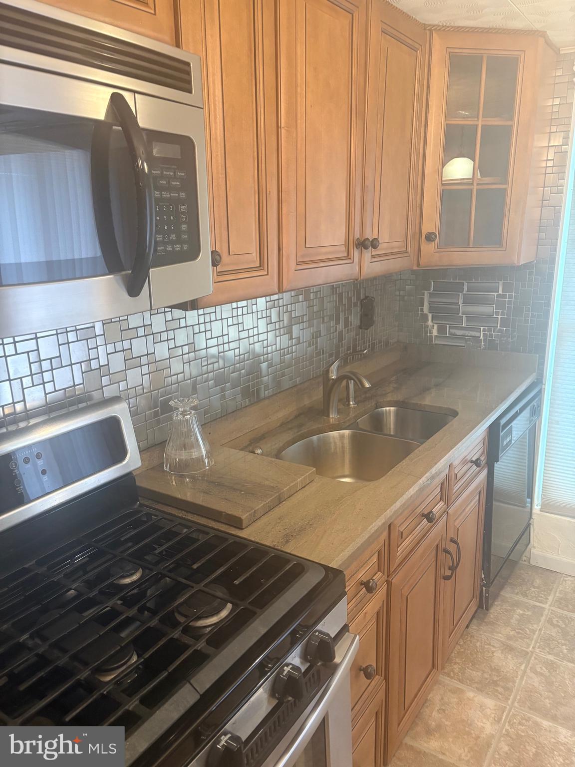 11829 Academy Road, Unit 29B Philadelphia, PA 19154 - Photo 9 of 33 a kitchen with granite countertop a sink and a stove