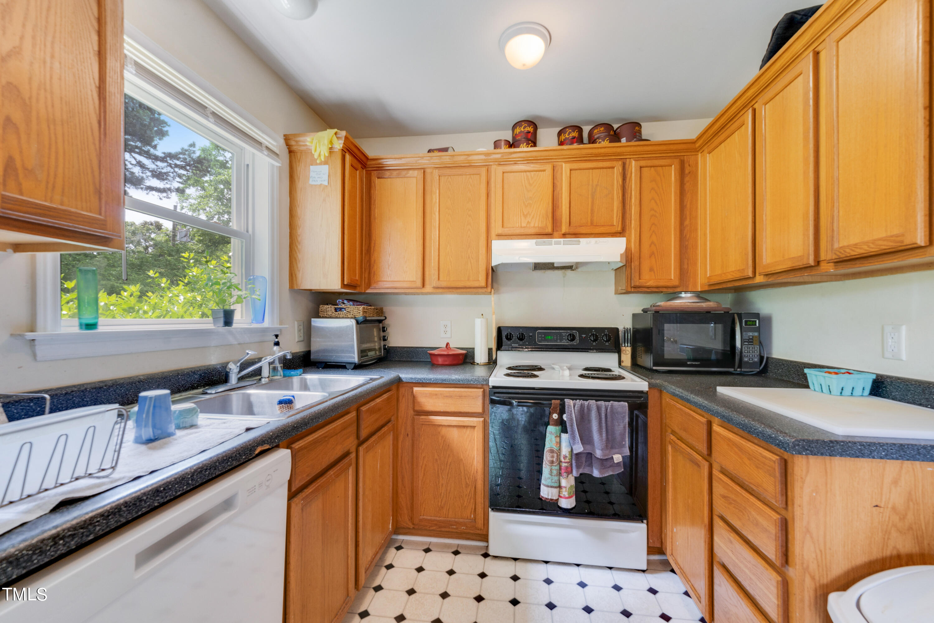 1005 Chaney Road Raleigh, NC 27606 - Photo 4 of 18 a kitchen with stainless steel appliances a stove a sink a refrigerator and cabinets