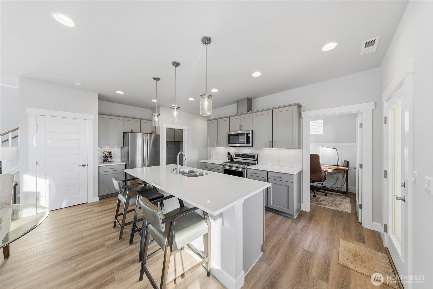 405 Maple Avenue La Conner, WA 98257 - Photo 7 of 40 a open dining room with stainless steel appliances kitchen island granite countertop a table chairs and a refrigerator