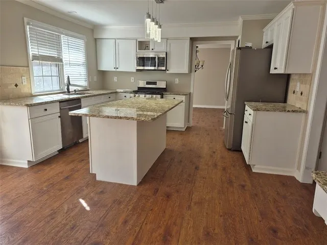 a kitchen with a refrigerator sink and wooden floor