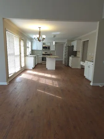 a view of a kitchen with a sink a cabinet and windows