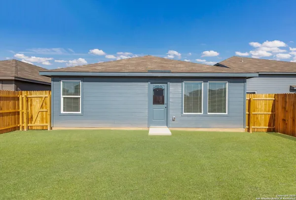 a backyard of a house with table and chairs