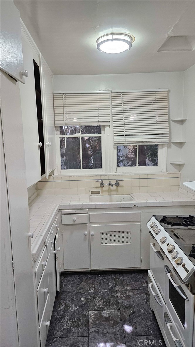 209 South Reeves Drive Beverly Hills, CA 90212 - Photo 4 of 8 a kitchen with a stove and a sink
