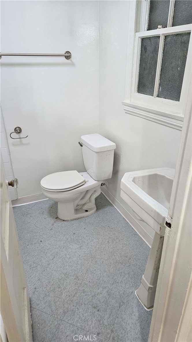 209 South Reeves Drive Beverly Hills, CA 90212 - Photo 8 of 8 a white toilet sitting next to a white sink and vanity