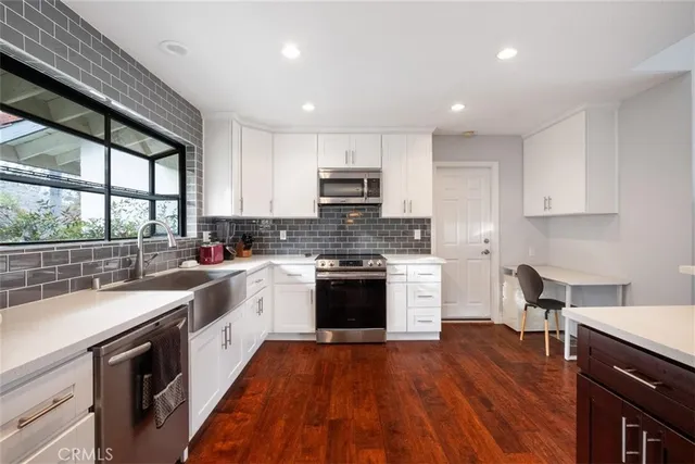 a kitchen with a sink a stove and cabinets