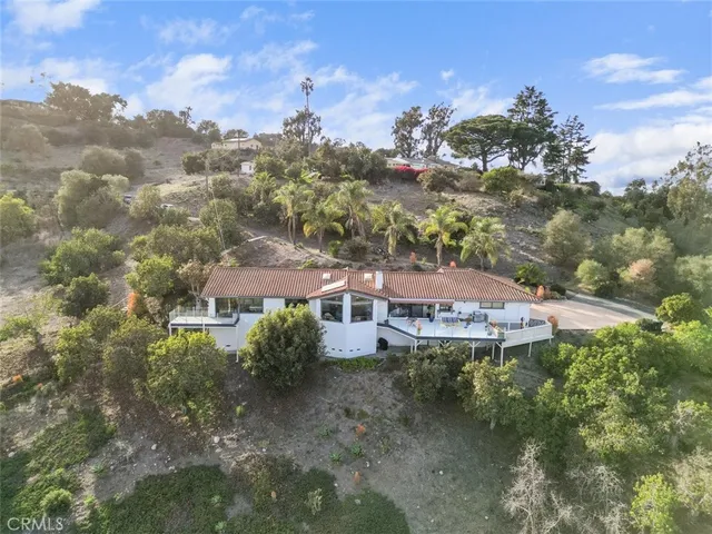 an aerial view of house with yard and mountain view in back