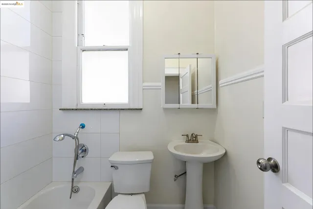 a bedroom with a bed and a lamp on dresser