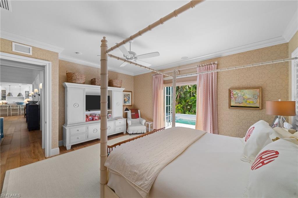 390 Windward Way Naples, FL 34103 - Photo 22 of 42 a bedroom with a large bed and a flat tv screen