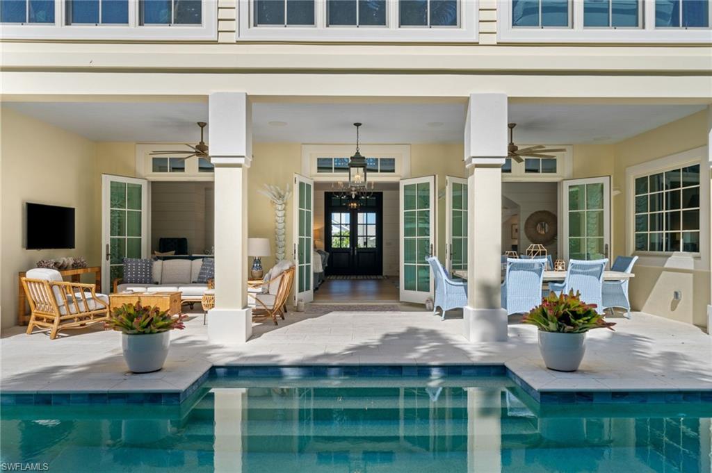 390 Windward Way Naples, FL 34103 - Photo 3 of 42 a dining table with chairs and potted plants