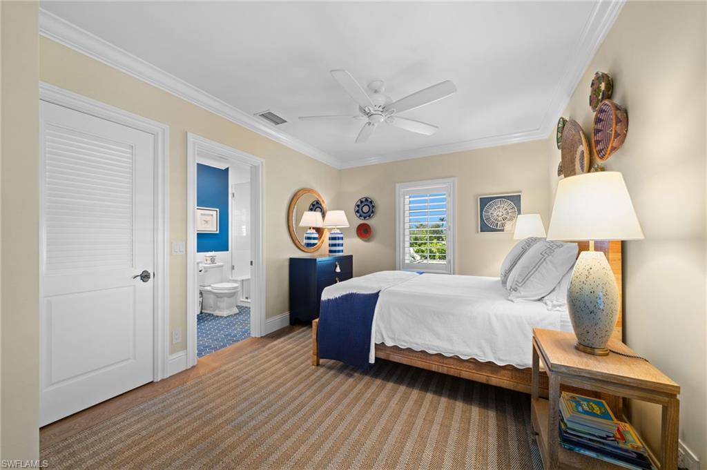 390 Windward Way Naples, FL 34103 - Photo 34 of 42 a bedroom with a bed and wooden floor
