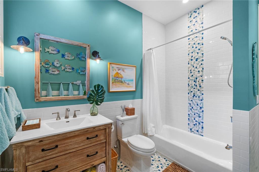 390 Windward Way Naples, FL 34103 - Photo 37 of 42 a bathroom with a granite countertop toilet a sink a mirror a bathtub and shower