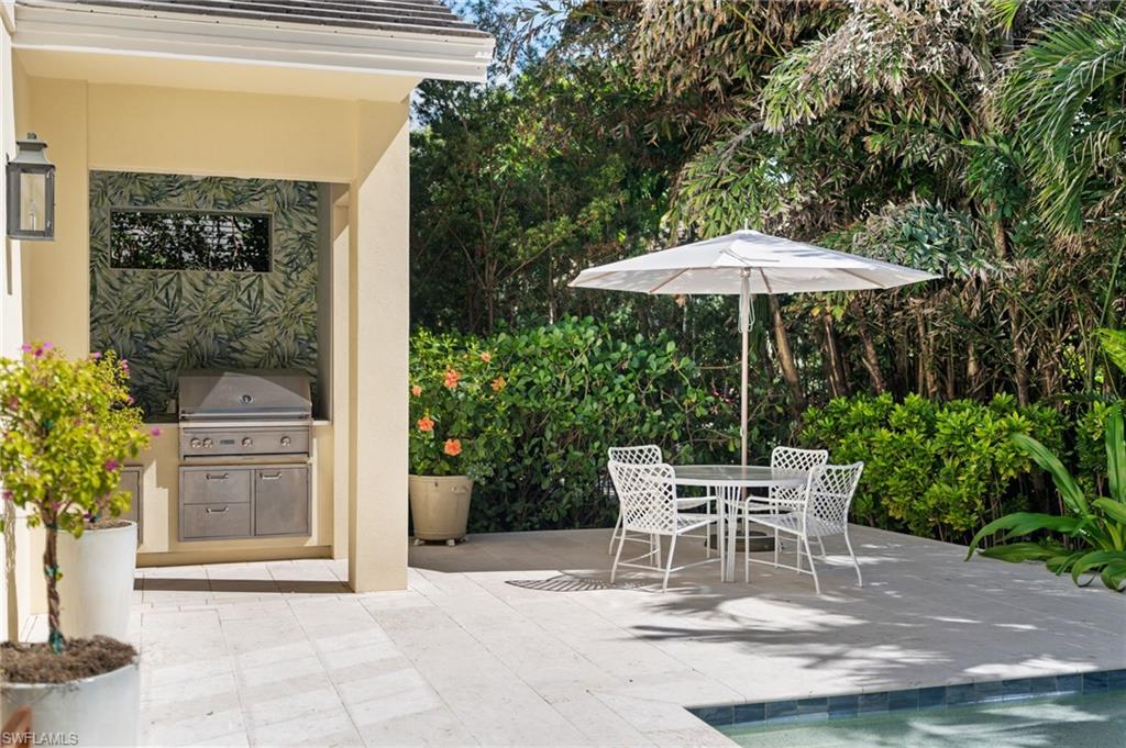 390 Windward Way Naples, FL 34103 - Photo 7 of 42 a patio with a patio table and chairs