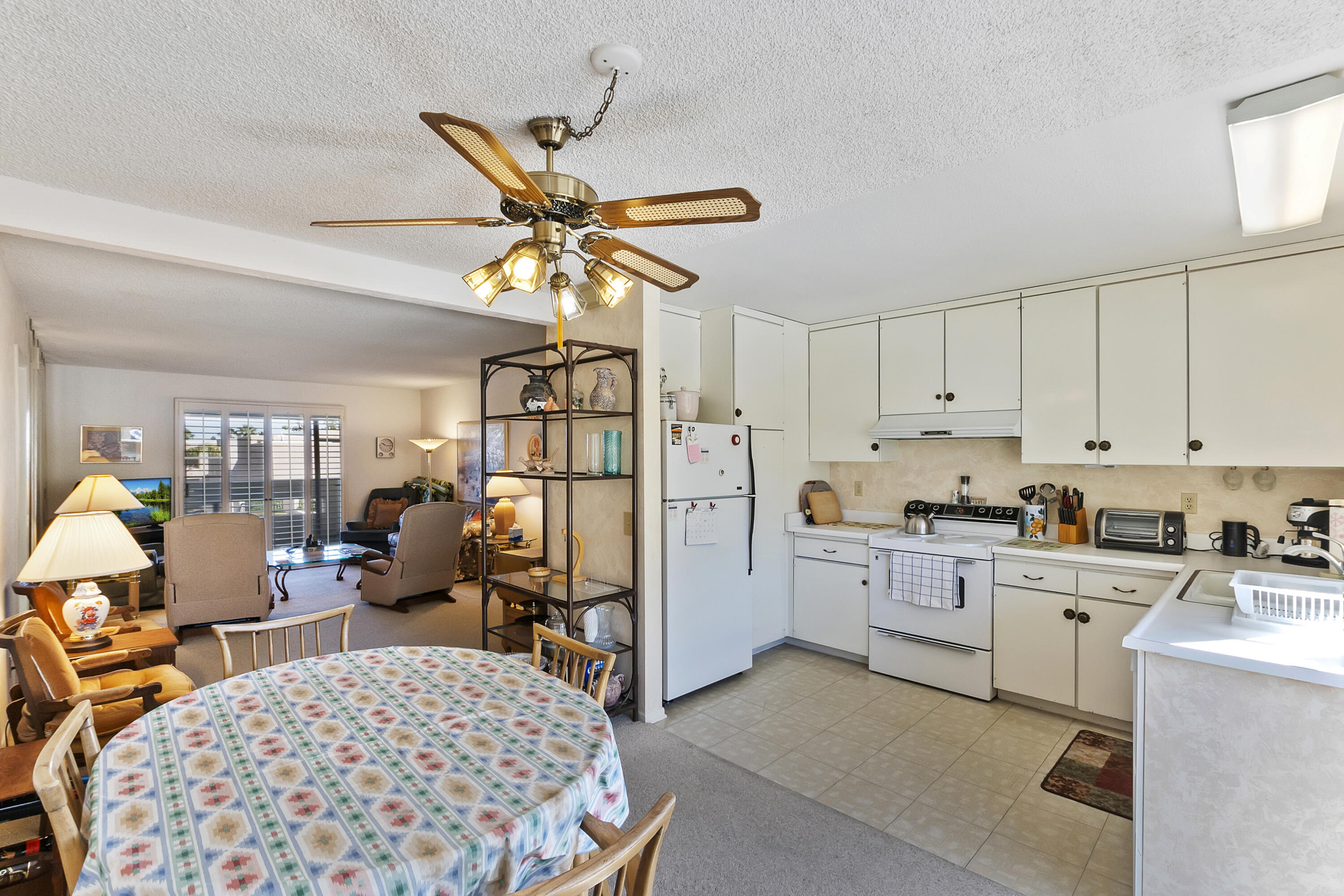 1268 Ramon Road, Unit 30 Palm Springs, CA 92264 - Photo 10 of 28 a kitchen with a refrigerator a stove cabinets and a dining table