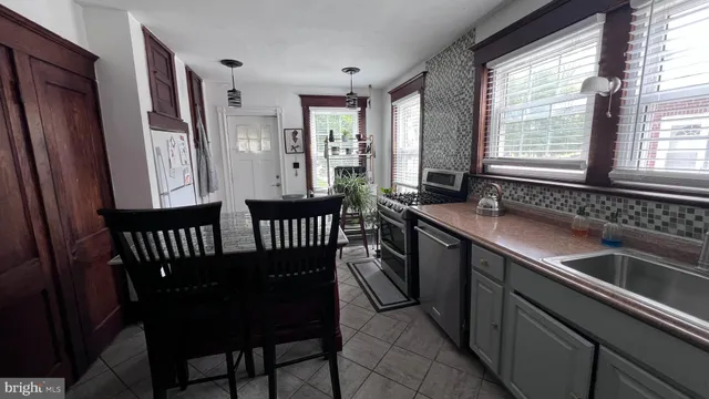 a kitchen with a table chairs sink and cabinets