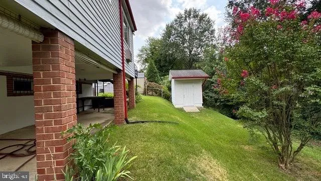 a view of a backyard with barn and large trees