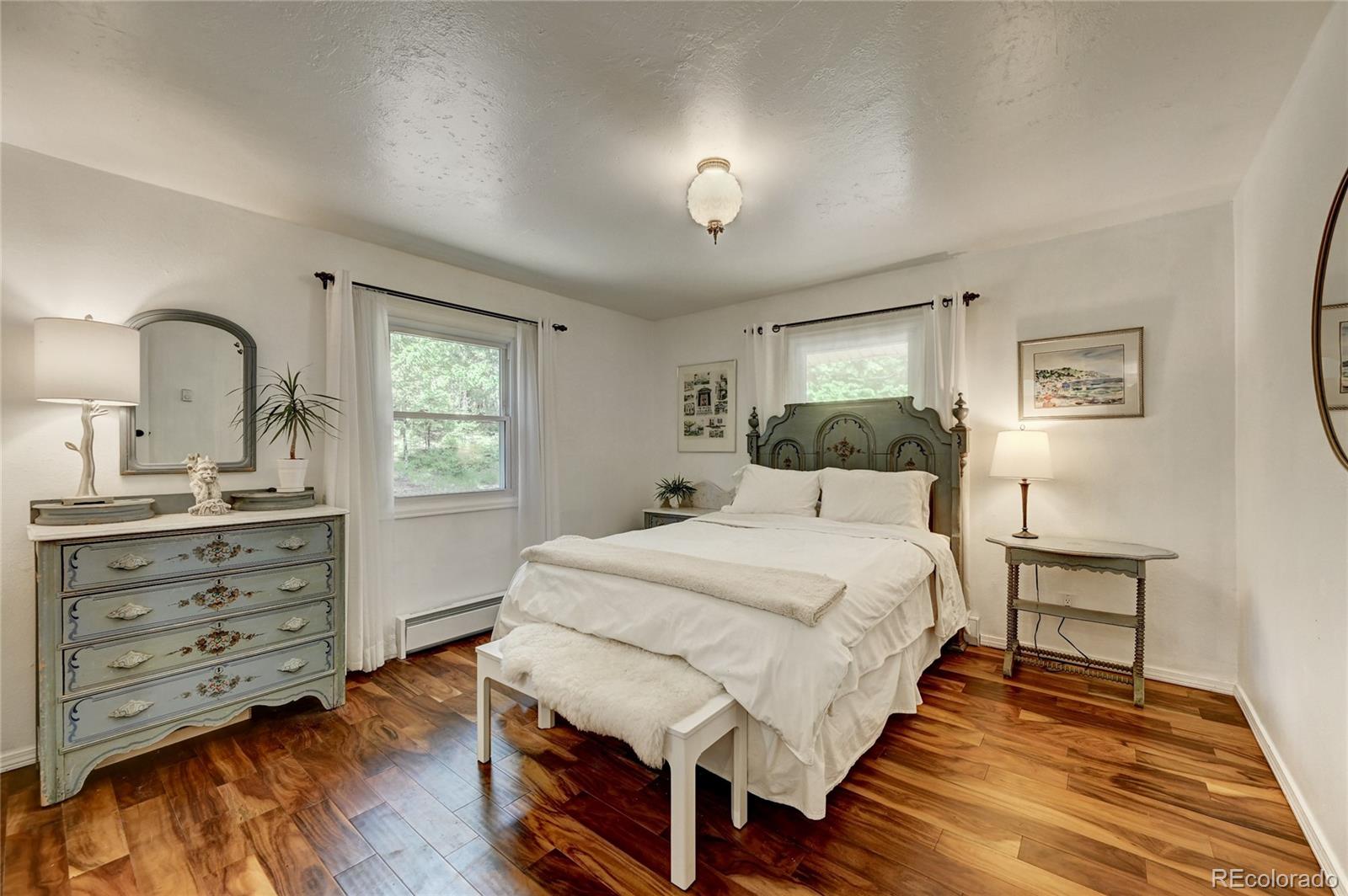 6549 Modoc Lane Evergreen, CO 80439 - Photo 15 of 39 a bedroom with a bed and a dresser