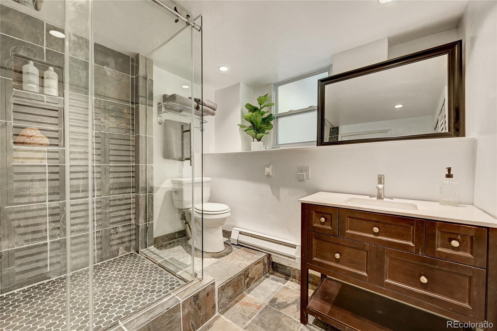 6549 Modoc Lane Evergreen, CO 80439 - Photo 20 of 39 a bathroom with a toilet sink and mirror