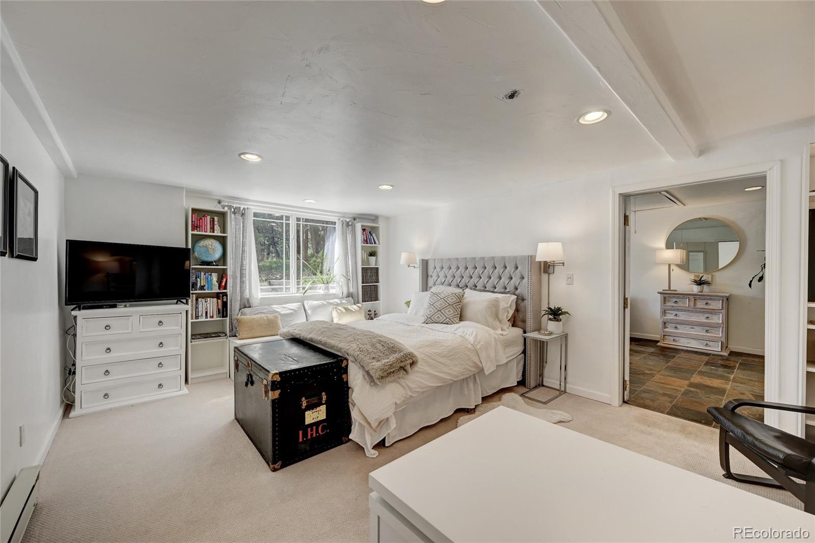 6549 Modoc Lane Evergreen, CO 80439 - Photo 29 of 39 a spacious bedroom with a bed and a flat screen tv