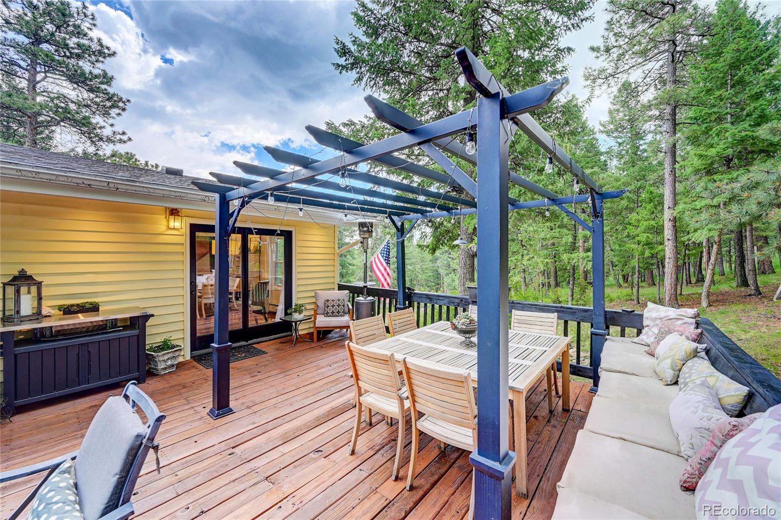 6549 Modoc Lane Evergreen, CO 80439 - Photo 30 of 39 a view of a patio with lawn chairs floor to ceiling window and wooden floor