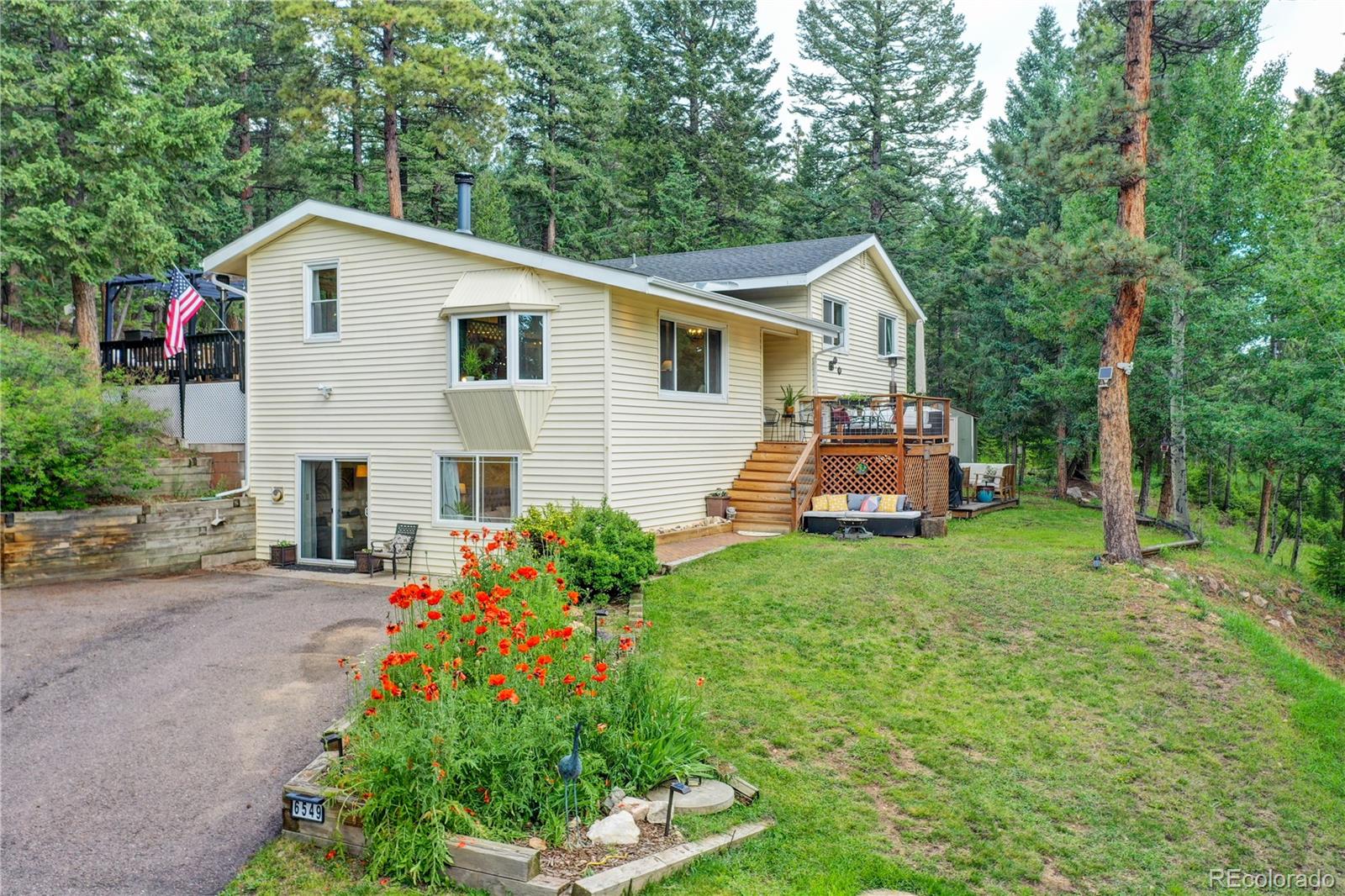 6549 Modoc Lane Evergreen, CO 80439 - Photo 3 of 39 a front view of a house with a yard and garage
