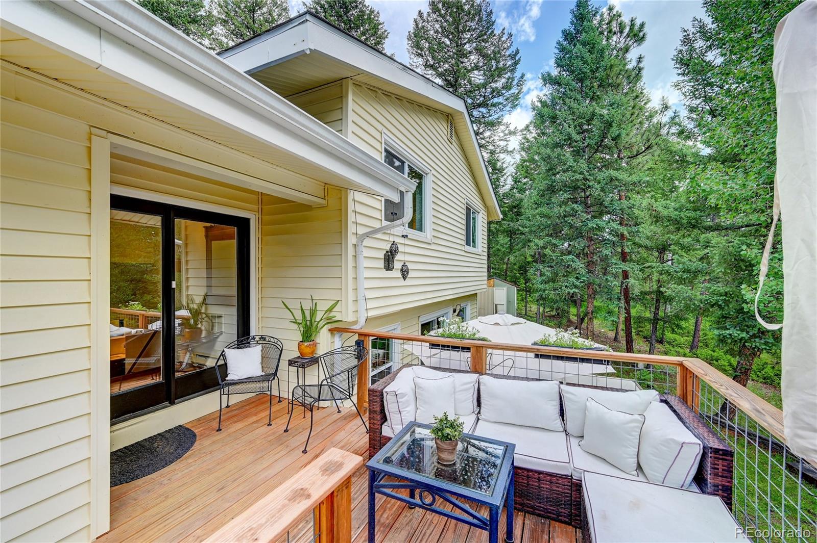6549 Modoc Lane Evergreen, CO 80439 - Photo 5 of 39 a view of deck with table and chairs under an umbrella with wooden floor