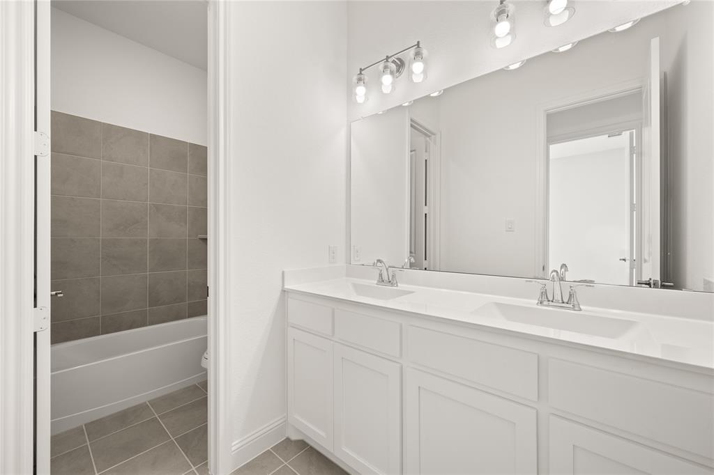 1016 Mill Ridge Drive Justin, TX 76247 - Photo 16 of 28 a bathroom with a double vanity sink and a mirror