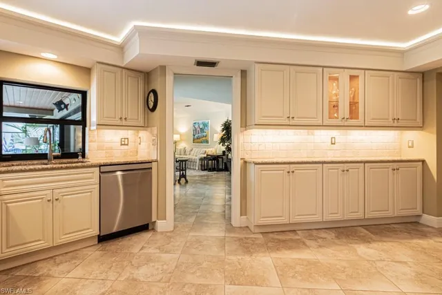 a kitchen with white cabinets and sink