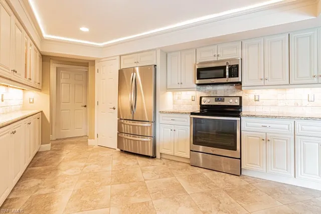 a kitchen with stainless steel appliances and white cabinets
