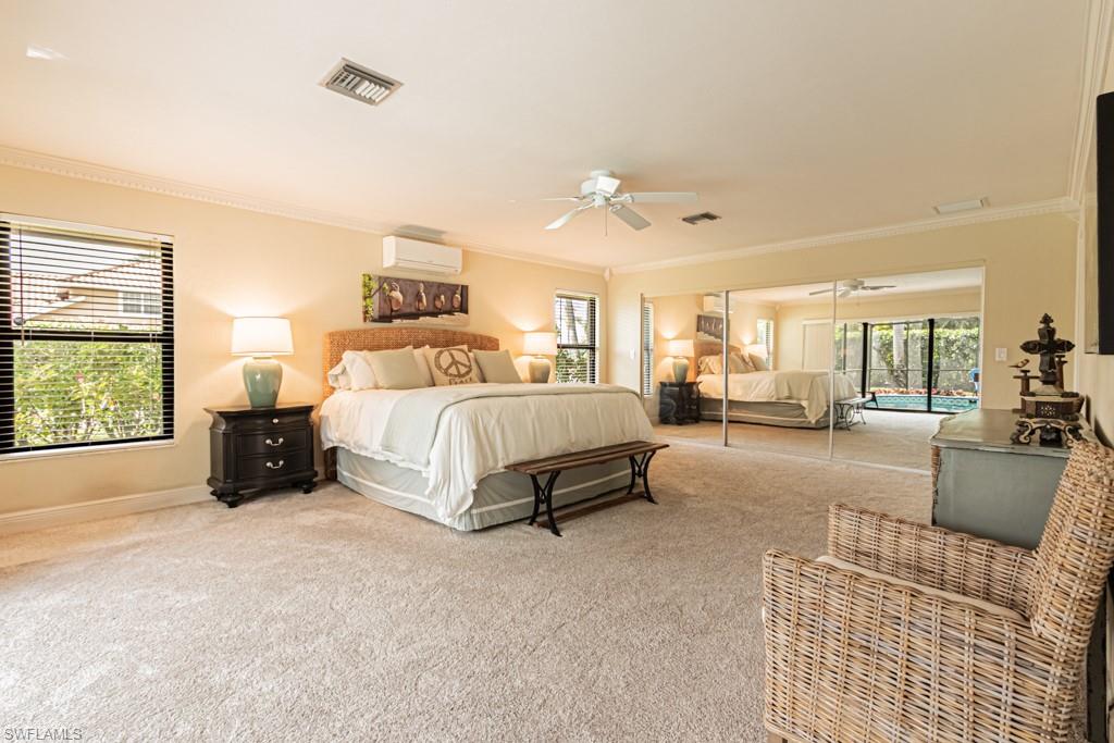 2308 Kings Lake Boulevard Naples, FL 34112 - Photo 18 of 36 a spacious bedroom with a bed a couch and a window