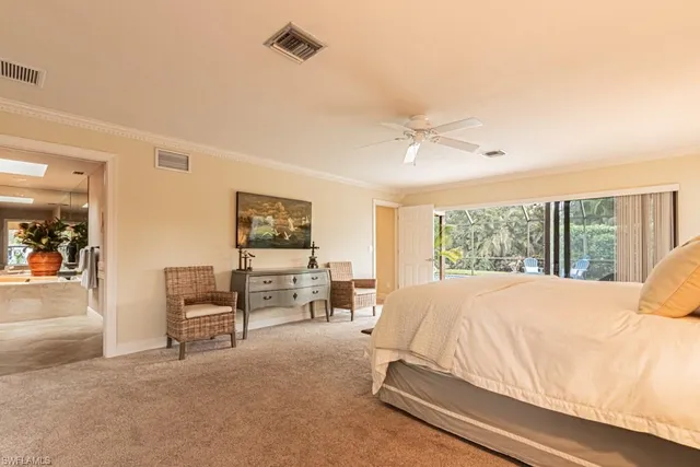 a bed sitting in a spacious bedroom next to a window
