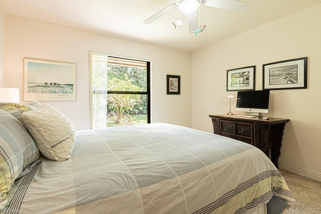 2308 Kings Lake Boulevard Naples, FL 34112 - Photo 24 of 36 a bedroom with a bed and wooden floor