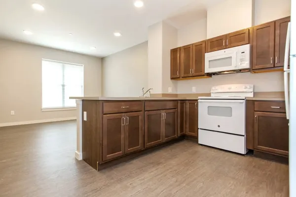 a kitchen with stainless steel appliances granite countertop a stove a sink and a microwave