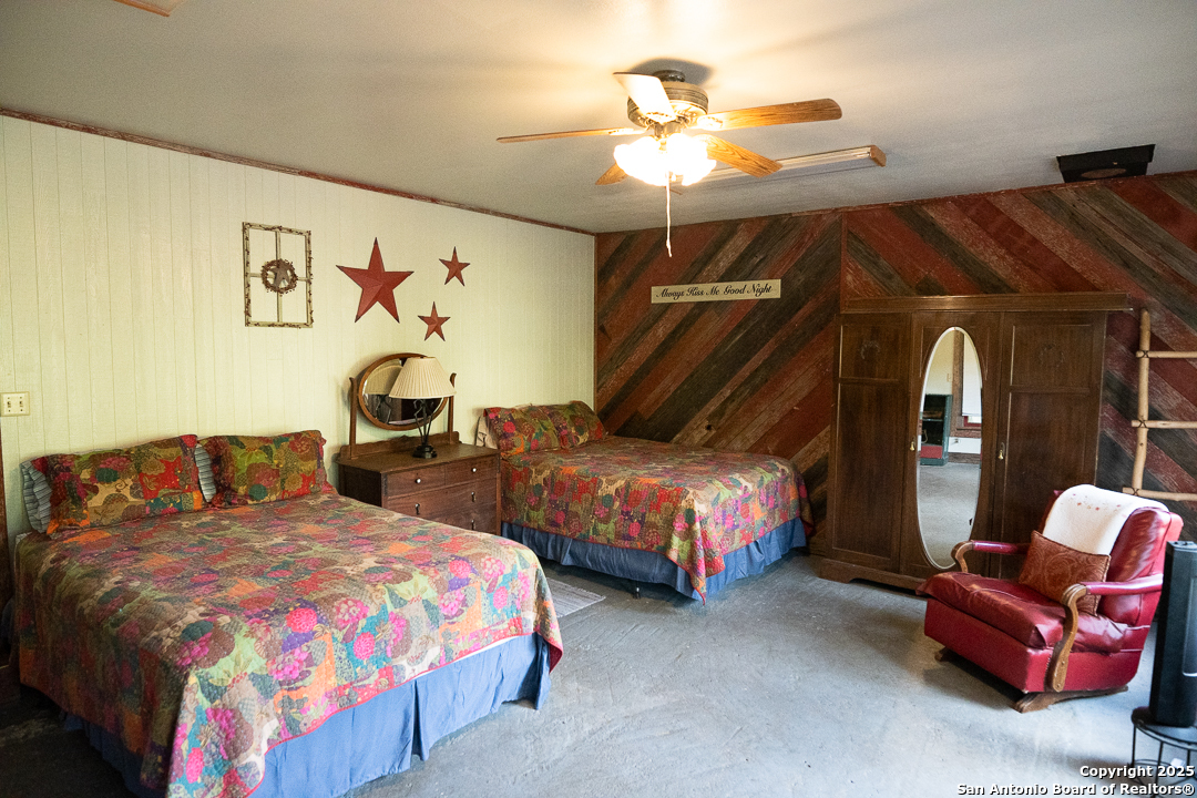 35298 Ranch To Market Road 187 Vanderpool, TX 78885 - Photo 16 of 29 a bedroom with two beds and painting on the wall