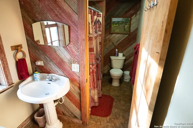 a bathroom with a sink a toilet and a mirror