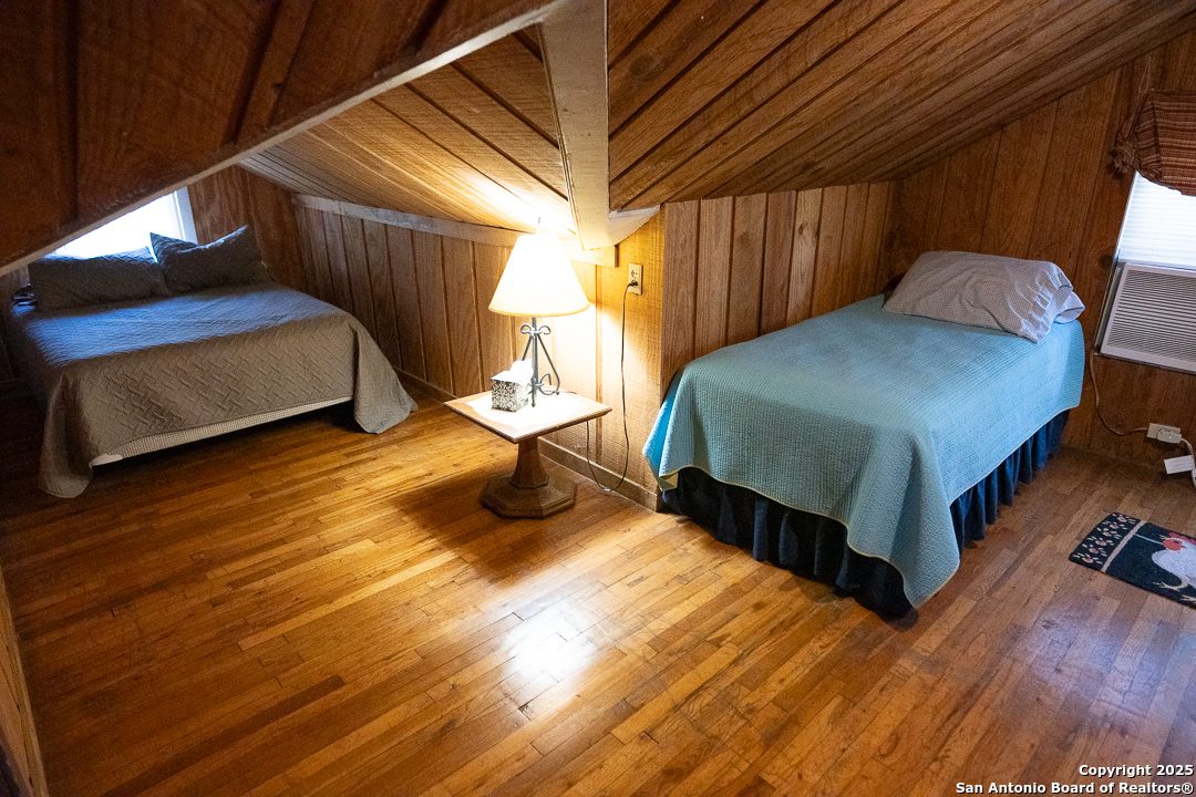 35298 Ranch To Market Road 187 Vanderpool, TX 78885 - Photo 26 of 29 a bedroom with a bed and wooden floor