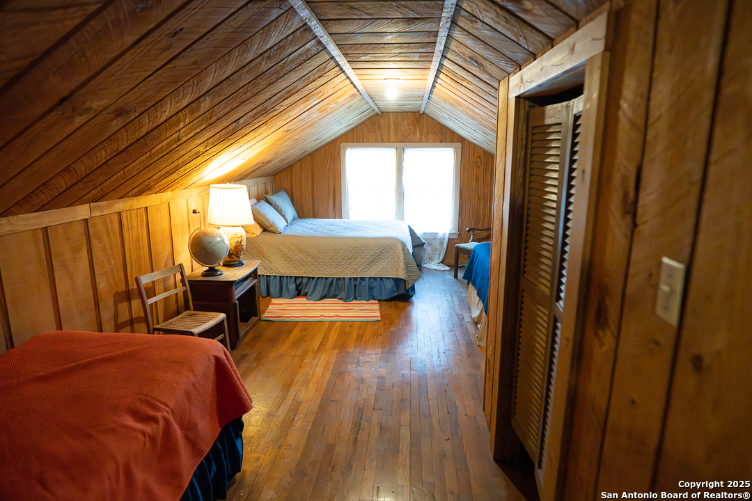 35298 Ranch To Market Road 187 Vanderpool, TX 78885 - Photo 27 of 29 a bedroom with a bed and a wooden floor