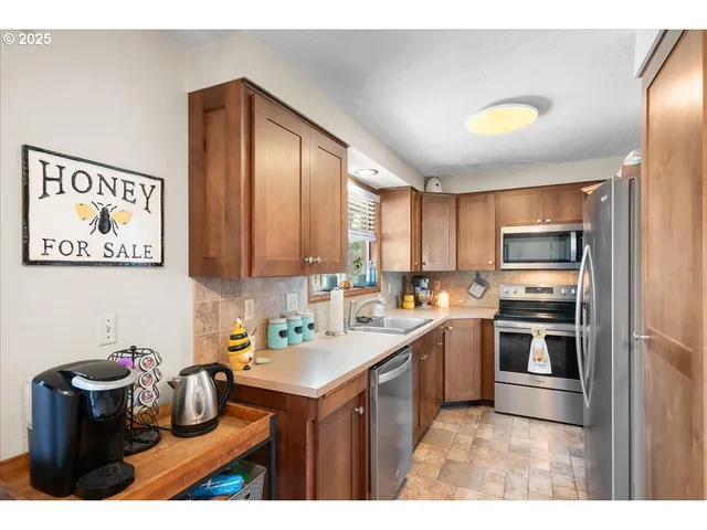 a kitchen with kitchen island a sink cabinets and stainless steel appliances