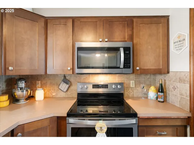 a kitchen with granite countertop a stove top oven microwave and cabinets