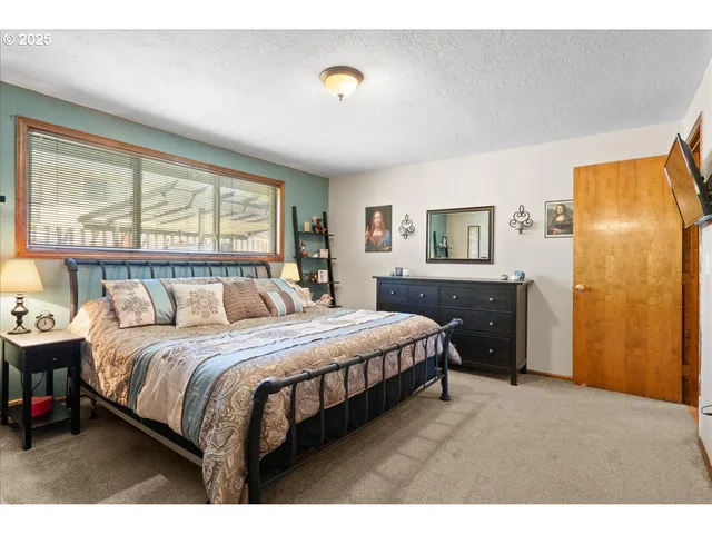 a bedroom with a bed and large windows