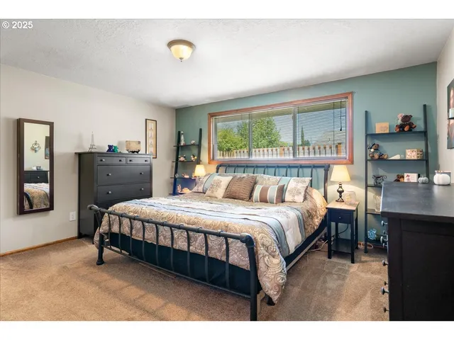 a bed room with a bed window and a dresser