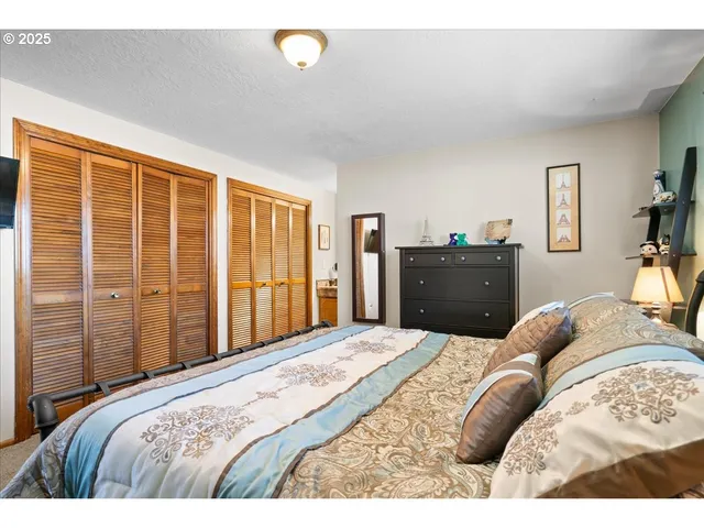 a bedroom with a bed and dresser with mirror